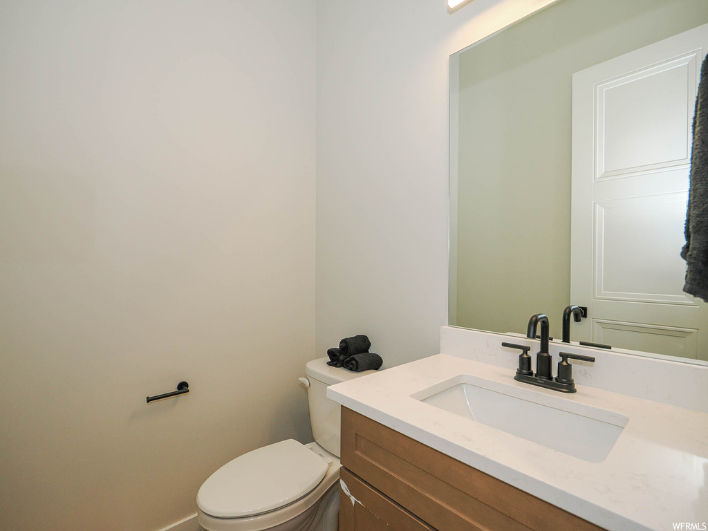 Bathroom featuring vanity with extensive cabinet space and mirror