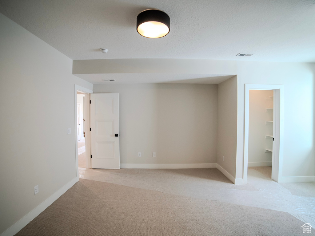 Carpeted empty room featuring a textured ceiling