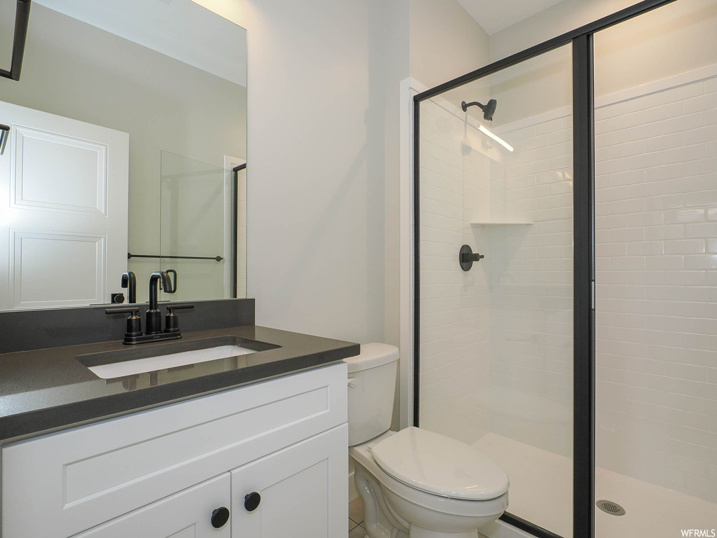 Bathroom with large vanity, a tile shower, and mirror