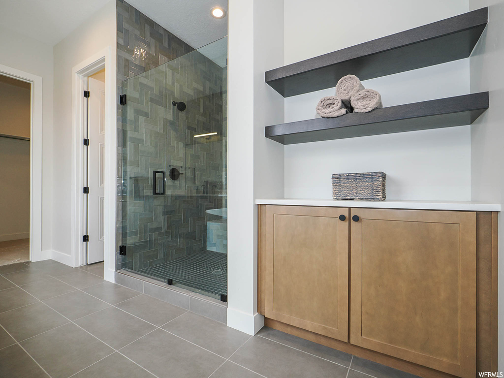 Bathroom with an enclosed shower and light tile floors