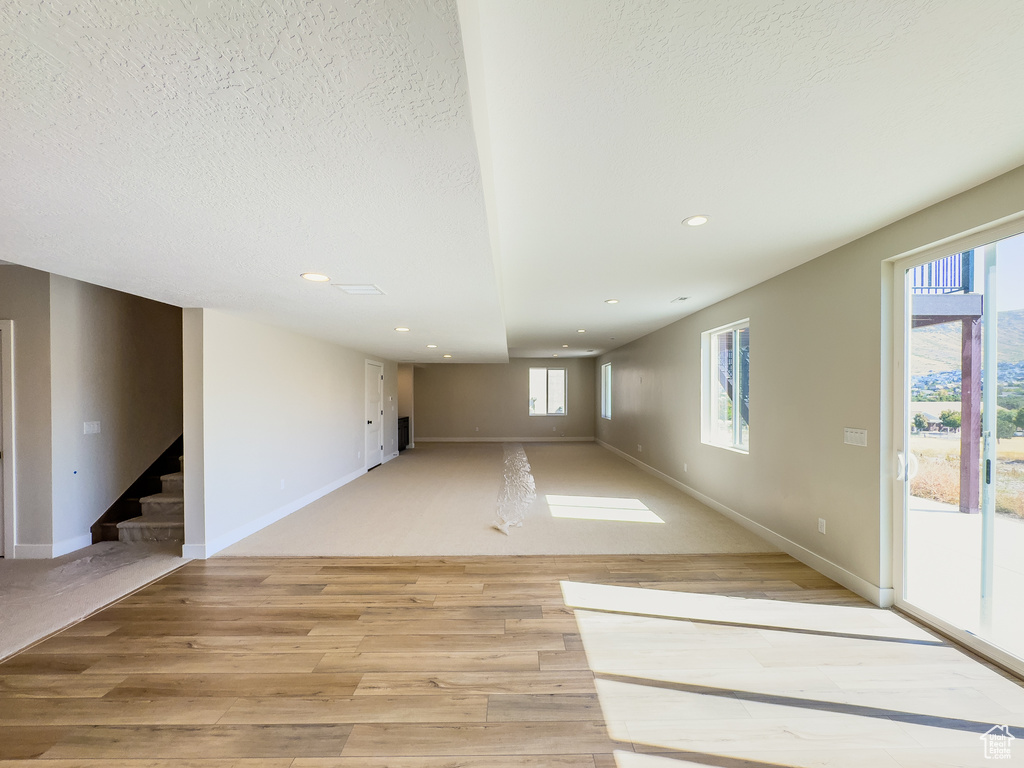 Empty room featuring a textured ceiling and light hardwood / wood-style floors