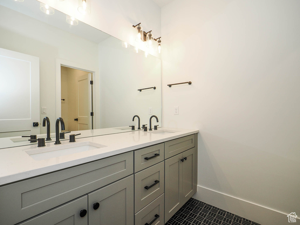 Bathroom with tile floors, large vanity, and dual sinks