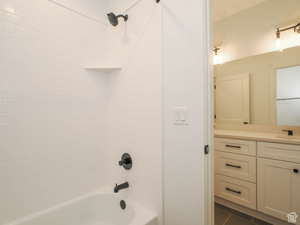 Bathroom with tile floors, tiled shower / bath combo, and vanity