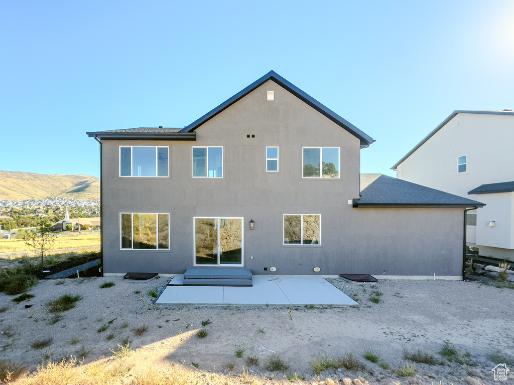 Rear view of property featuring a patio and a mountain view