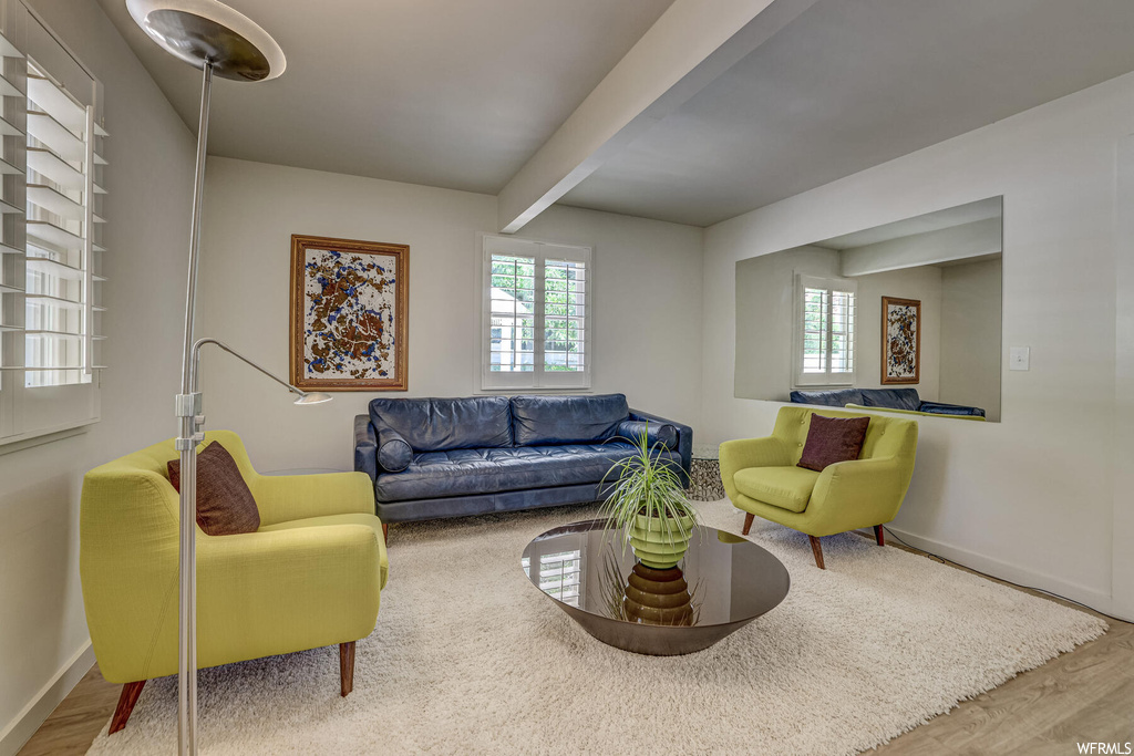 Living room featuring light hardwood flooring and beam ceiling