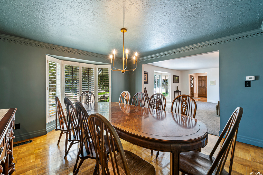 Dining space with a textured ceiling, light parquet flooring, and plenty of natural light