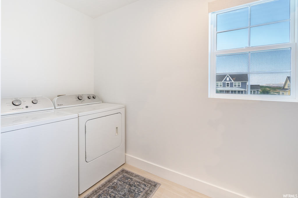 Laundry room featuring light hardwood flooring and washer and dryer