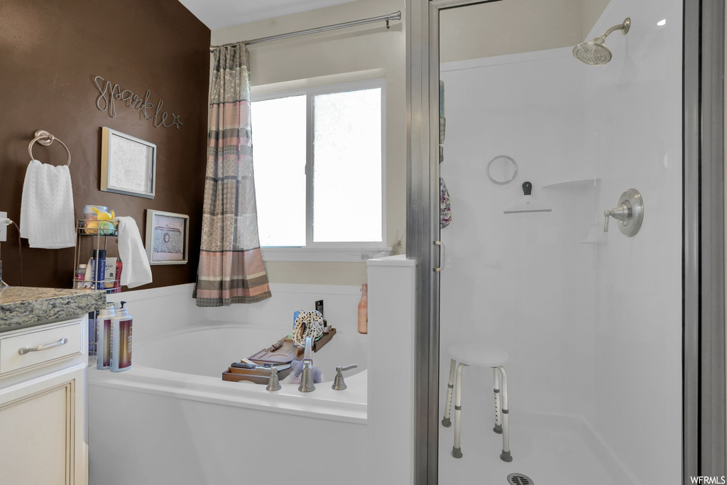 Bathroom featuring curtained shower, vanity, and a wealth of natural light