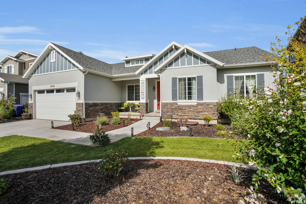 Craftsman-style house featuring garage and a front yard