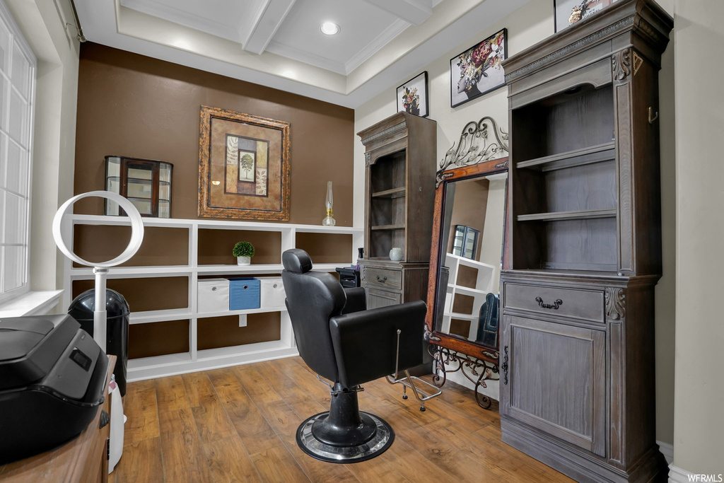 Wood floored office space featuring coffered ceiling, beam ceiling, and ornamental molding