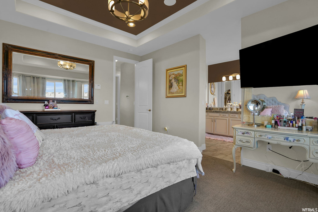 Bedroom with carpet floors and a tray ceiling