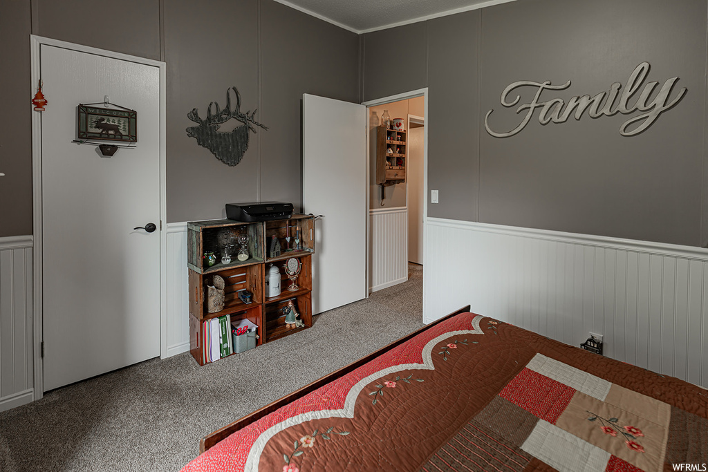 Carpeted bedroom featuring crown molding