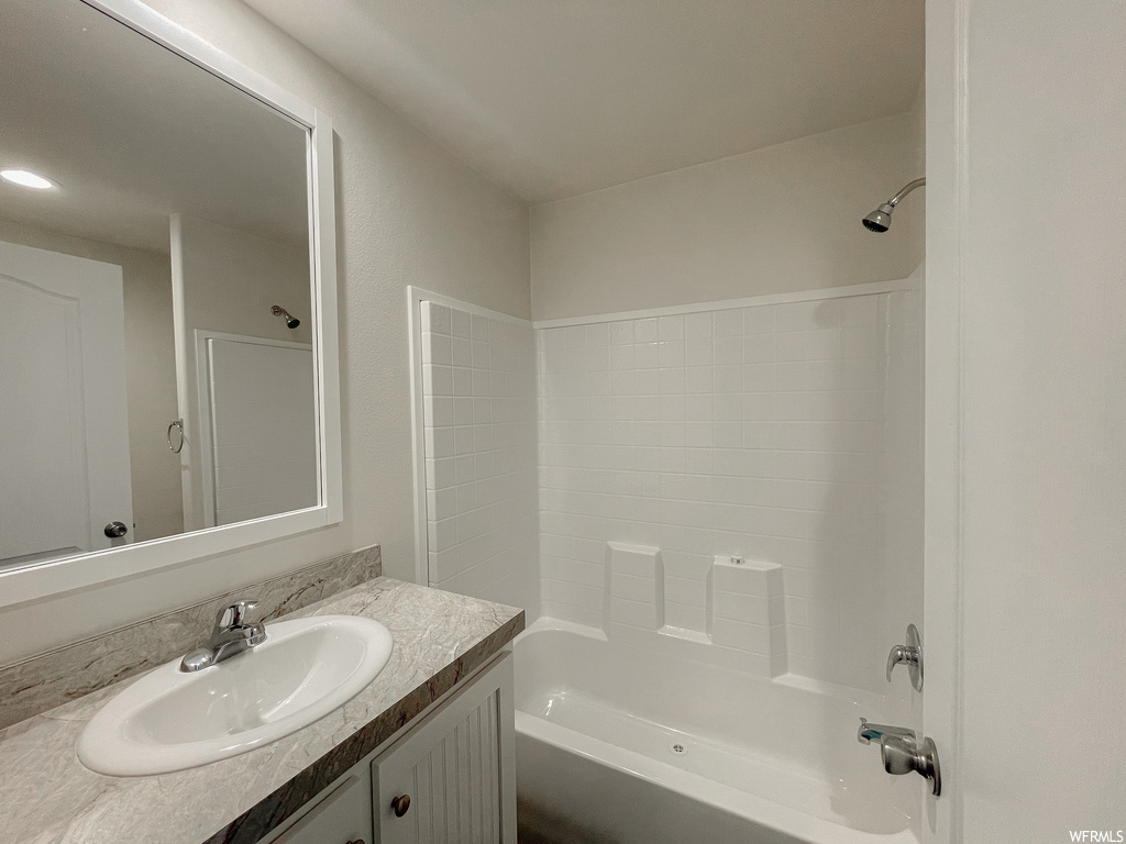 Bathroom with oversized vanity, shower / washtub combination, and mirror