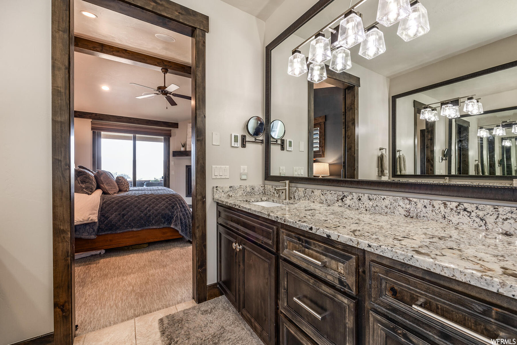 Bathroom featuring mirror, vanity, tile flooring, and ceiling fan