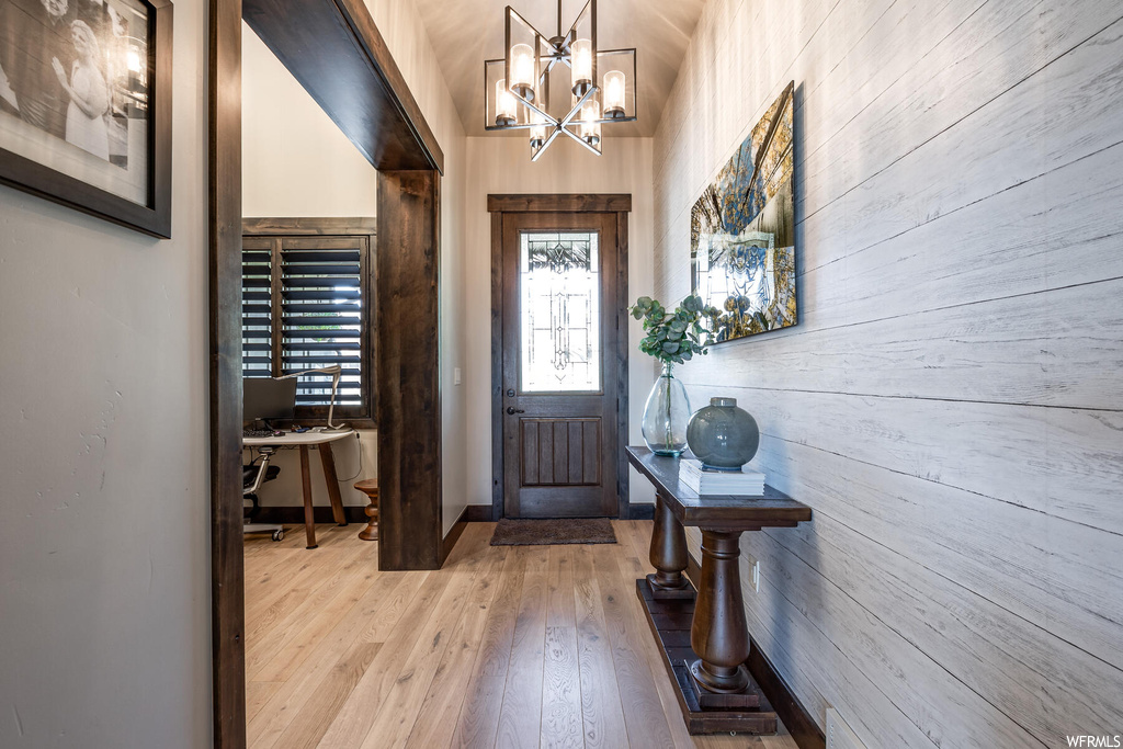 Foyer featuring light parquet floors and wood walls