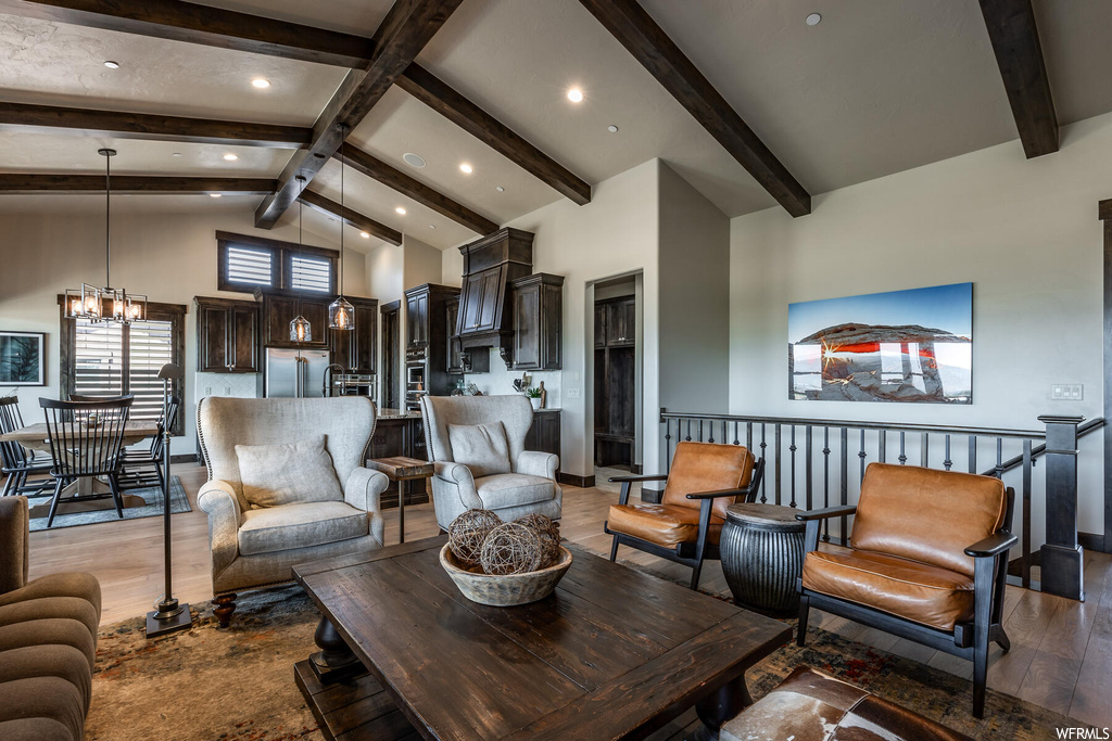 Hardwood floored living room with a high ceiling and lofted ceiling with beams