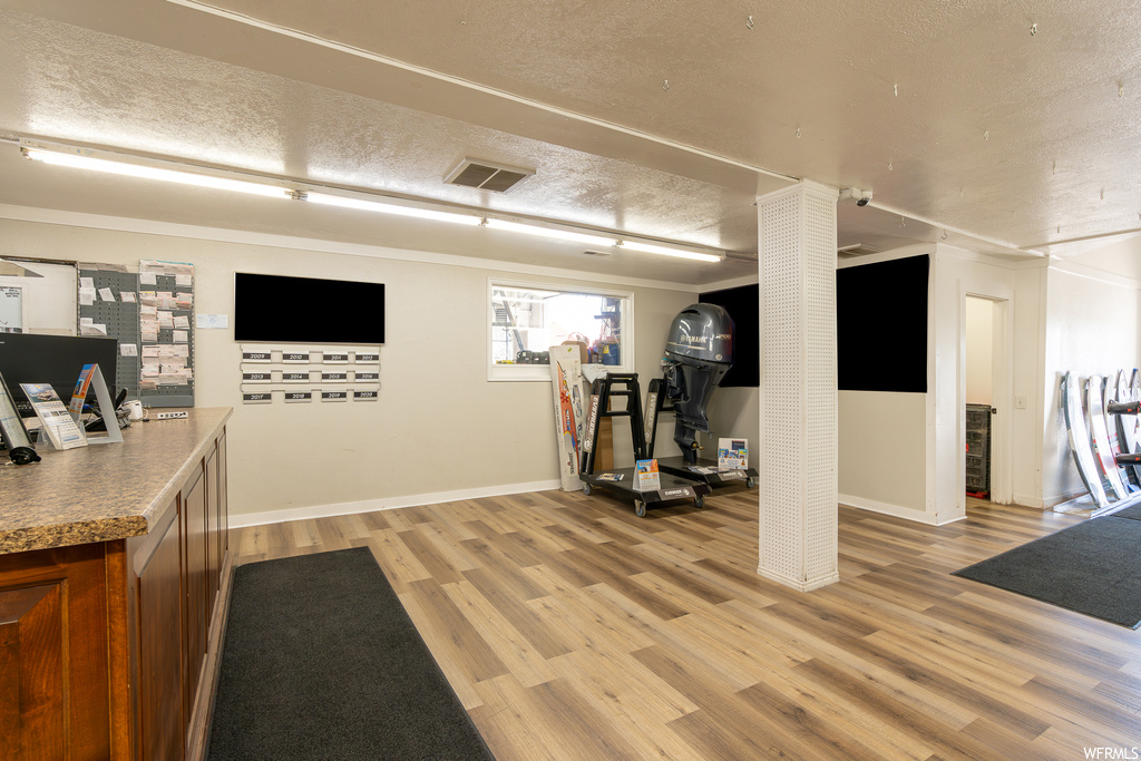 Interior space with light hardwood flooring and a textured ceiling