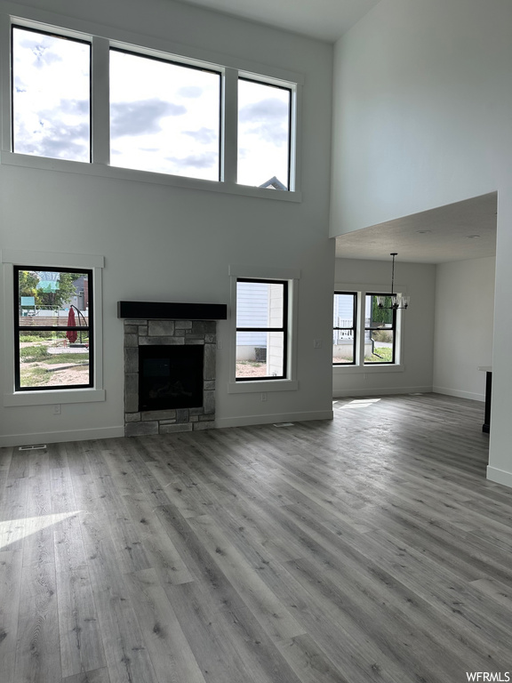 Hardwood floored living room featuring a high ceiling and a fireplace
