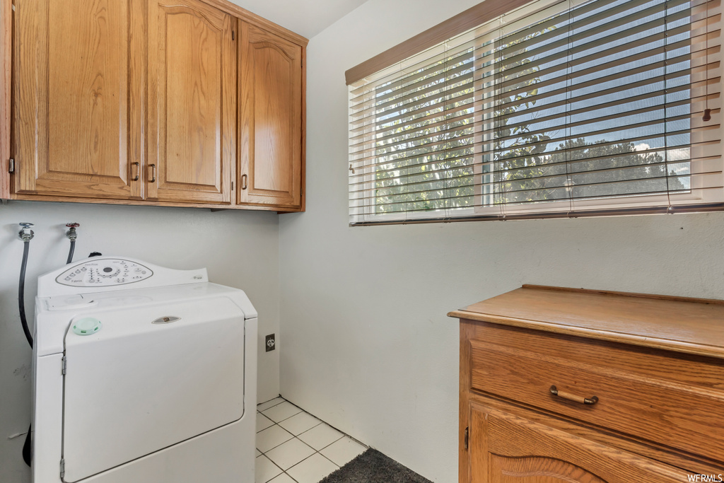 Washroom featuring light tile flooring and washer / dryer