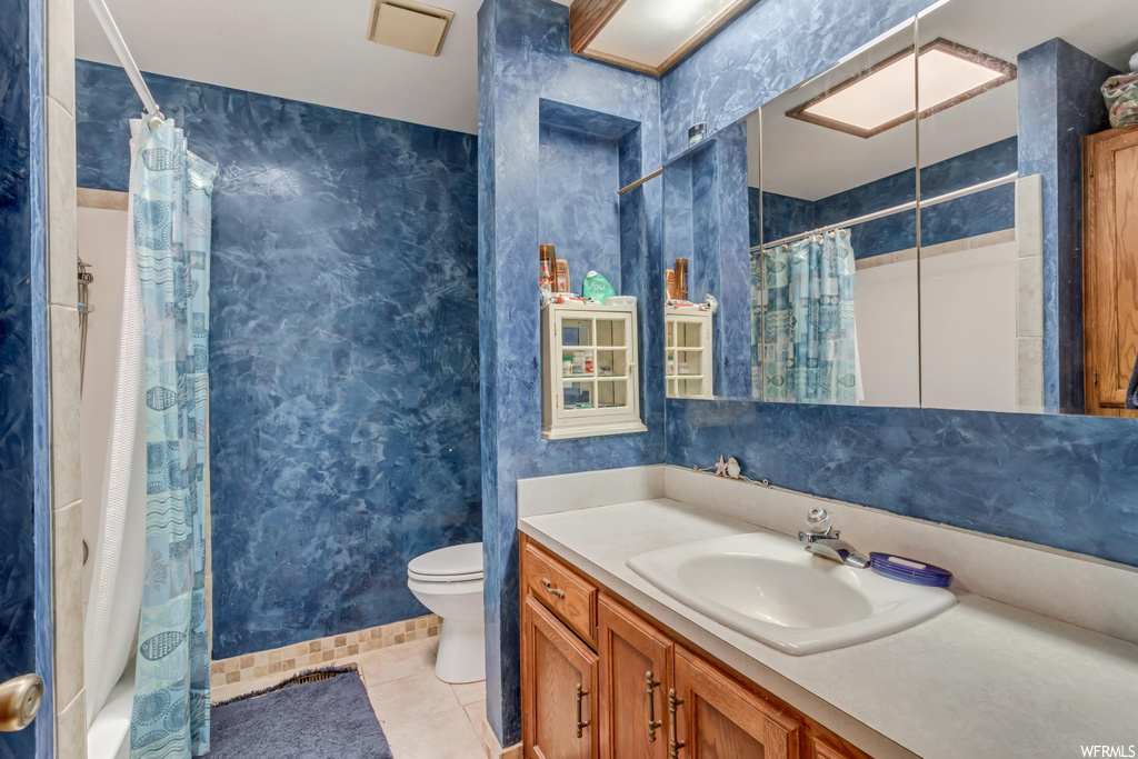 Bathroom featuring tile flooring, large vanity, and mirror