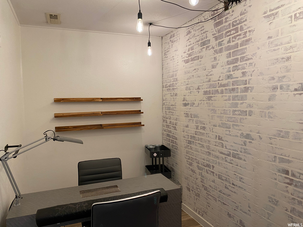 Home office with brick wall and crown molding