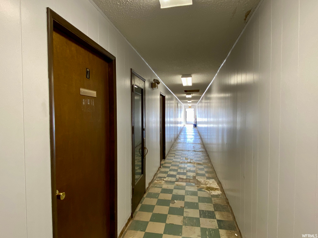 Hall with a textured ceiling and tile floors