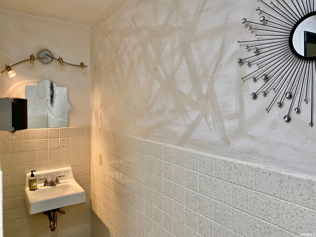 Bathroom with washbasin, tile walls, and mirror