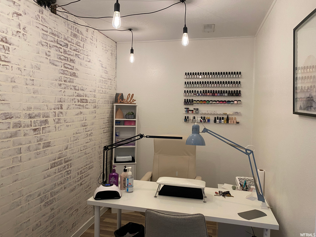 Office space with crown molding and brick wall