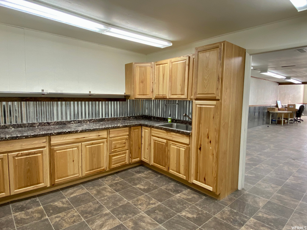 Kitchen with dark tile flooring and dark countertops