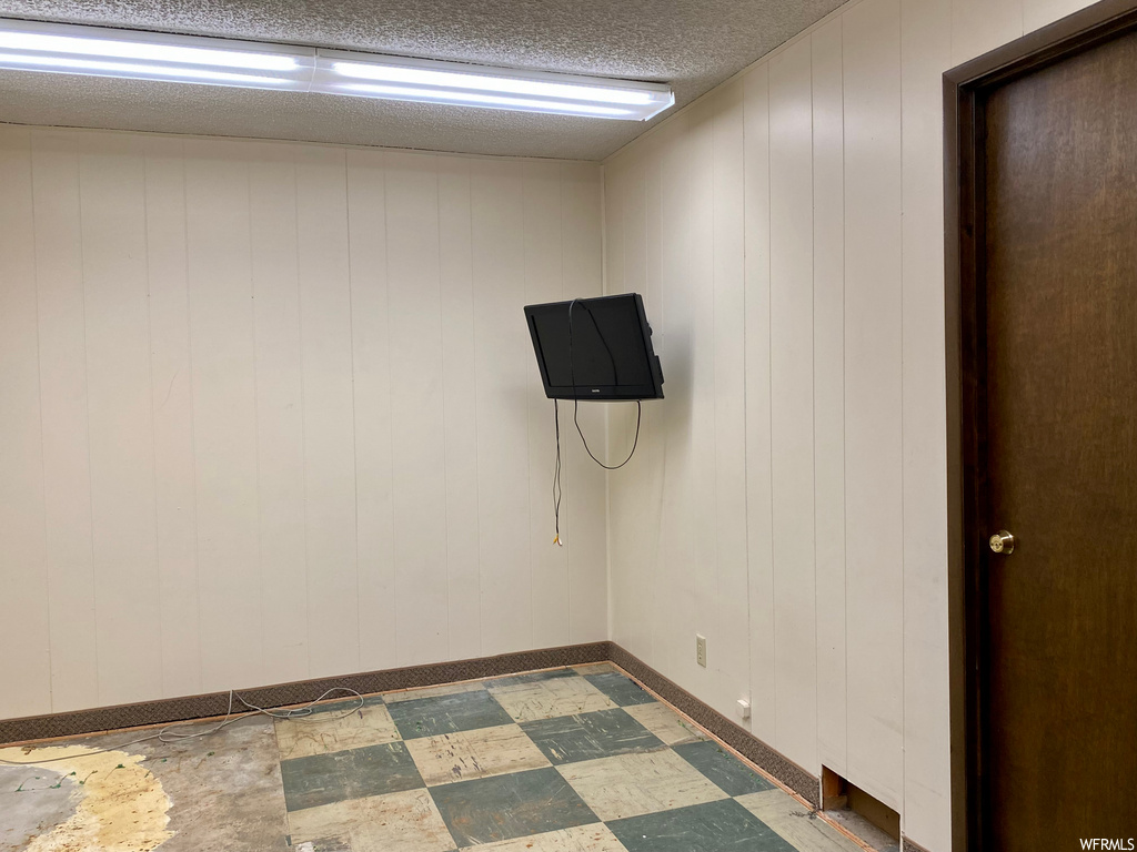 Tiled spare room featuring a textured ceiling