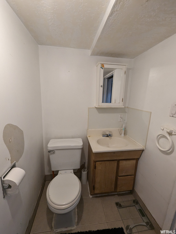 Bathroom with mirror, large vanity, and tile floors