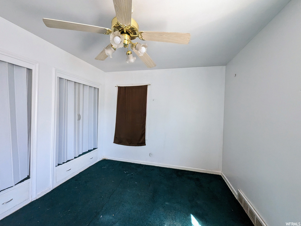 Spare room with ceiling fan and carpet floors
