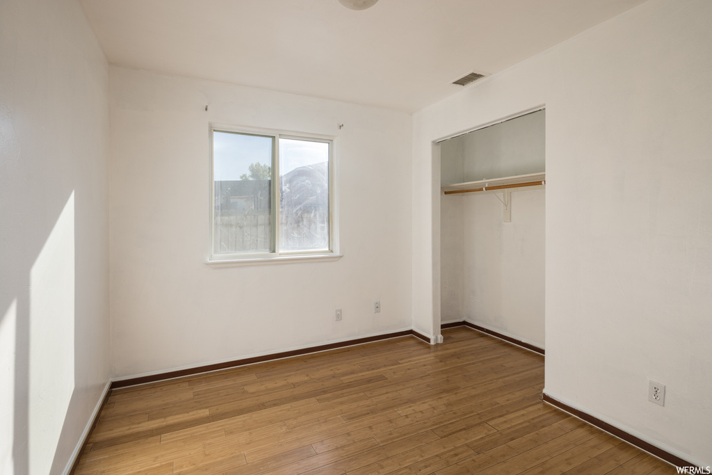 Unfurnished bedroom with light hardwood / wood-style flooring and a closet