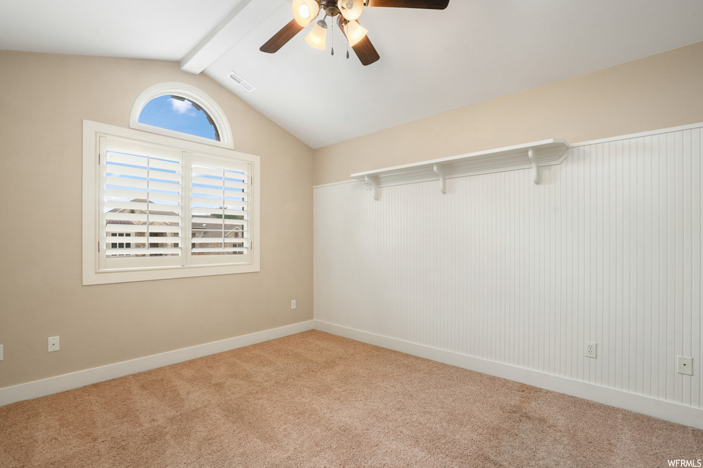 Unfurnished room featuring lofted ceiling with beams, light carpet, and ceiling fan