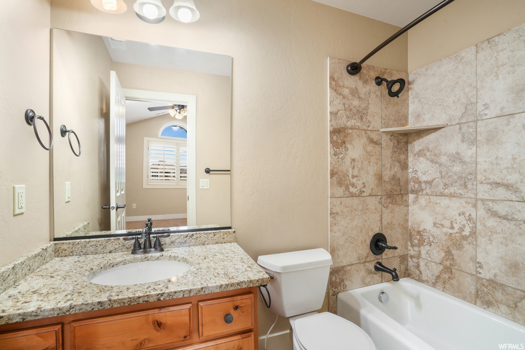 Full bathroom with ceiling fan, oversized vanity, tiled shower / bath combo, and mirror