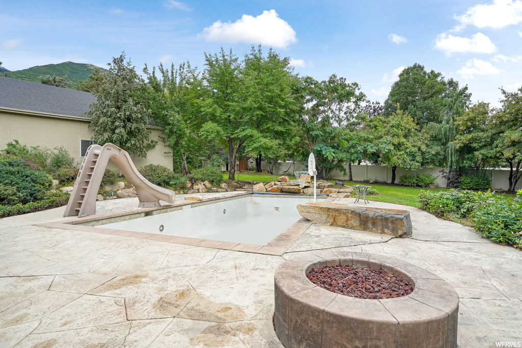 View of swimming pool featuring a firepit and a patio area