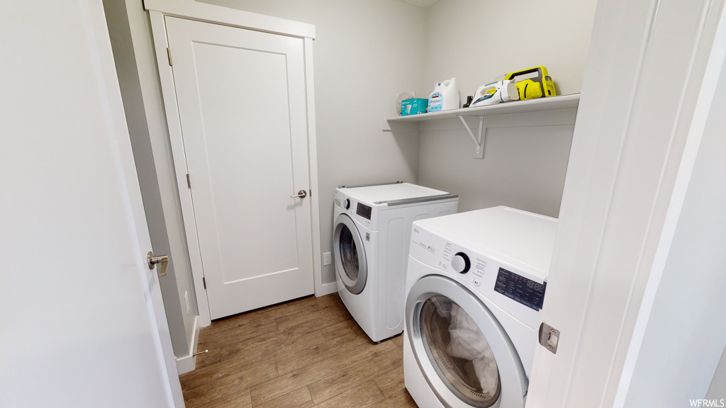 Laundry room with washer / clothes dryer and light hardwood floors