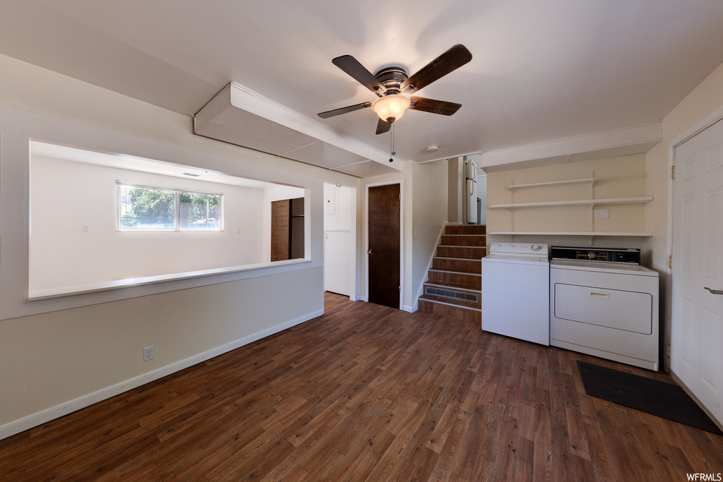 Kitchen with dark hardwood flooring, white cabinets, ceiling fan, and washing machine and dryer