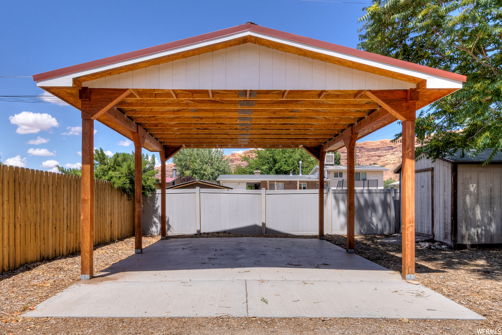 View of patio with carport and a storage shed