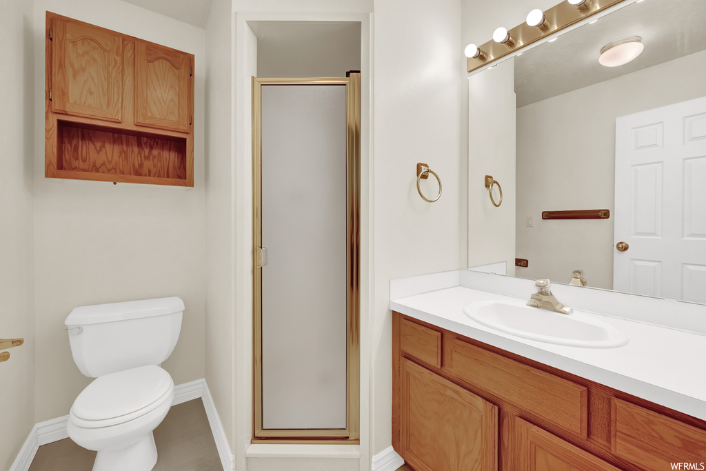 Bathroom featuring a shower with door, mirror, and oversized vanity