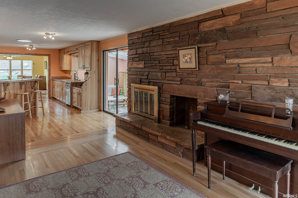 Hardwood floored living room featuring a fireplace and a textured ceiling