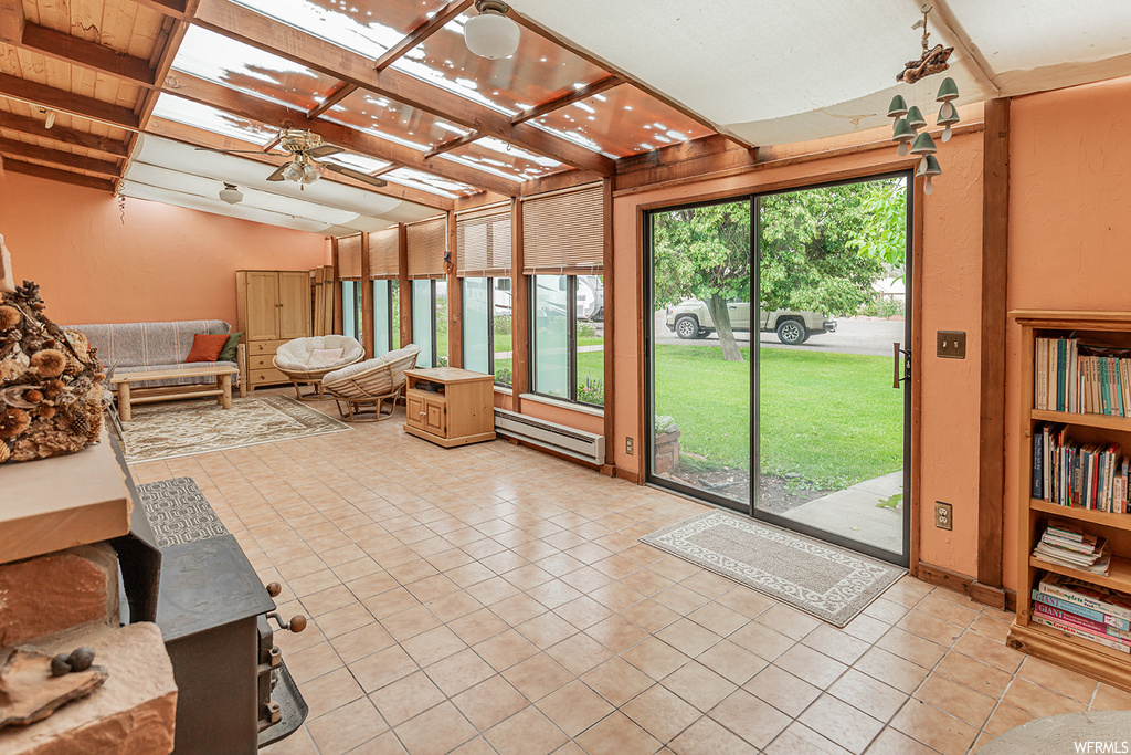 Sunroom / solarium with coffered ceiling, beamed ceiling, and ceiling fan