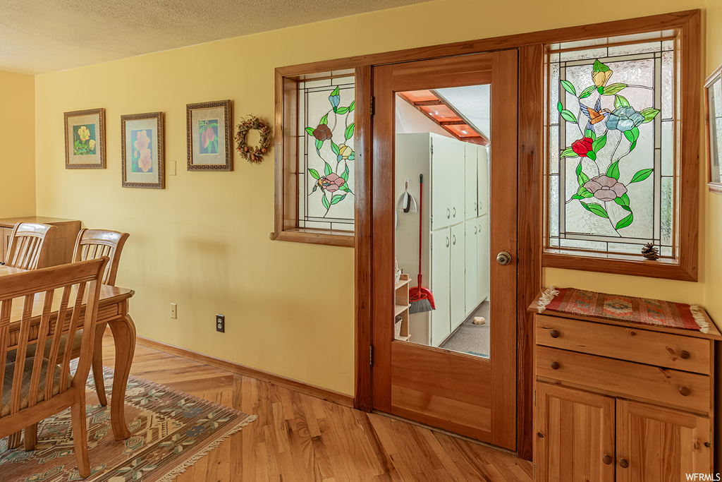 Hardwood floored entryway featuring a textured ceiling
