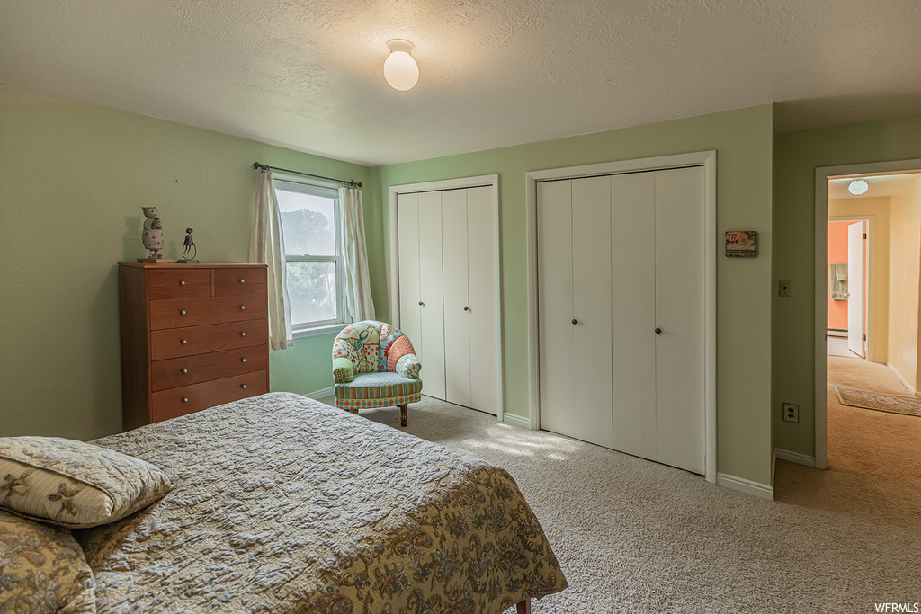 Bedroom featuring light carpet and a textured ceiling