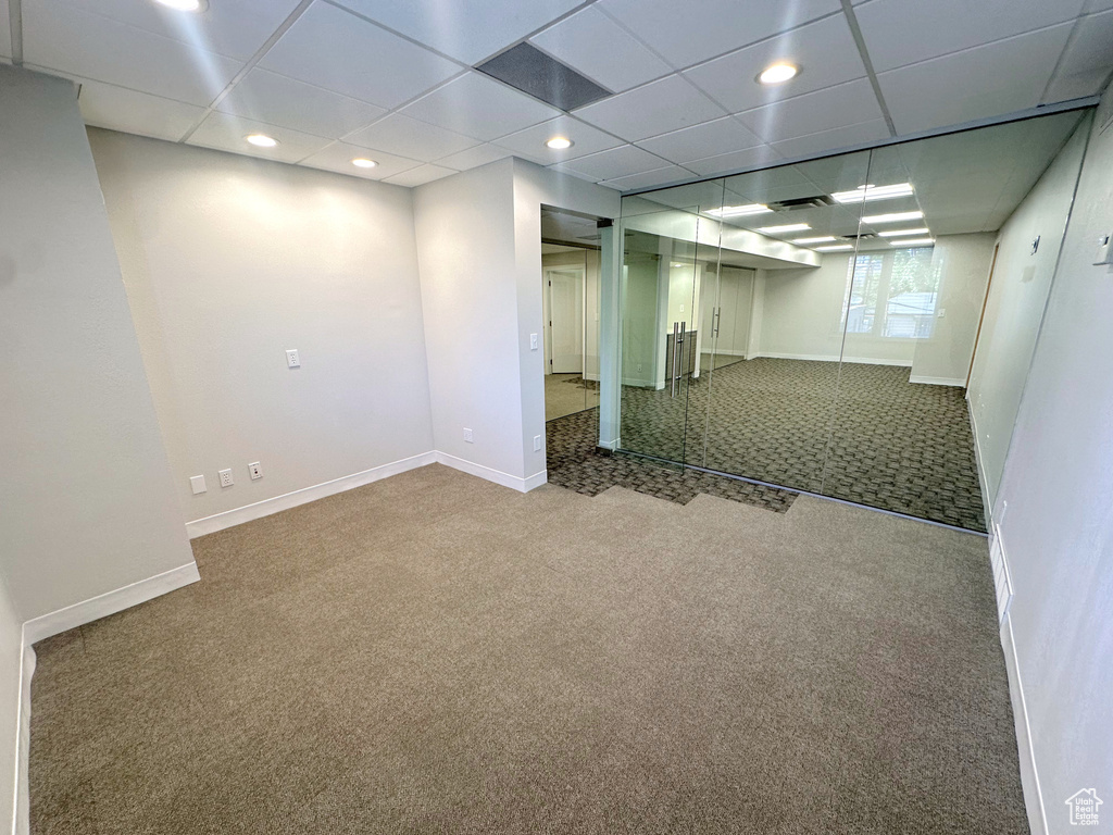 Basement featuring carpet and a drop ceiling