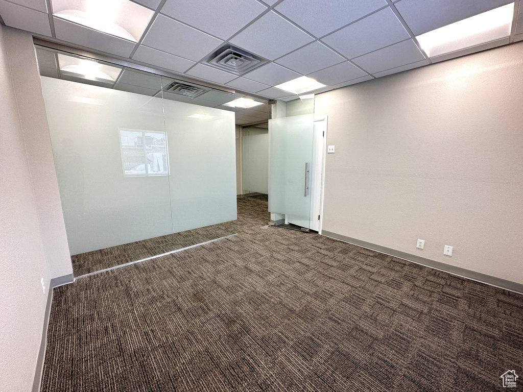 Interior space with dark carpet and a drop ceiling