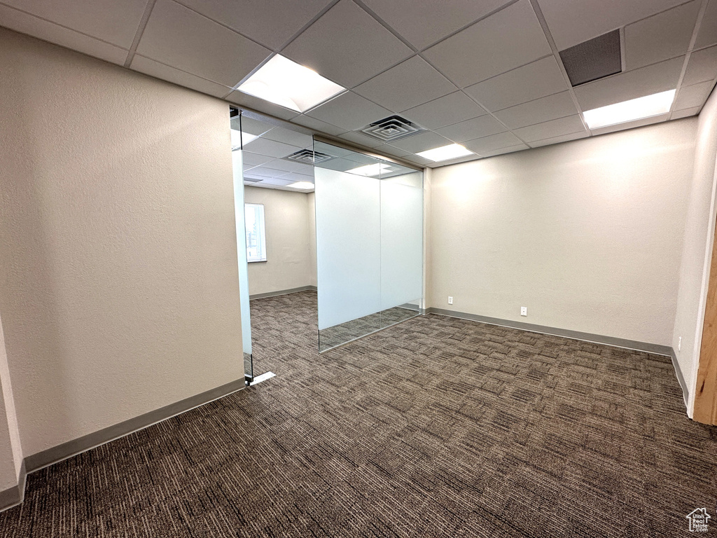 Carpeted empty room featuring a paneled ceiling