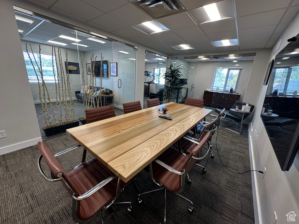 Carpeted dining area featuring a paneled ceiling