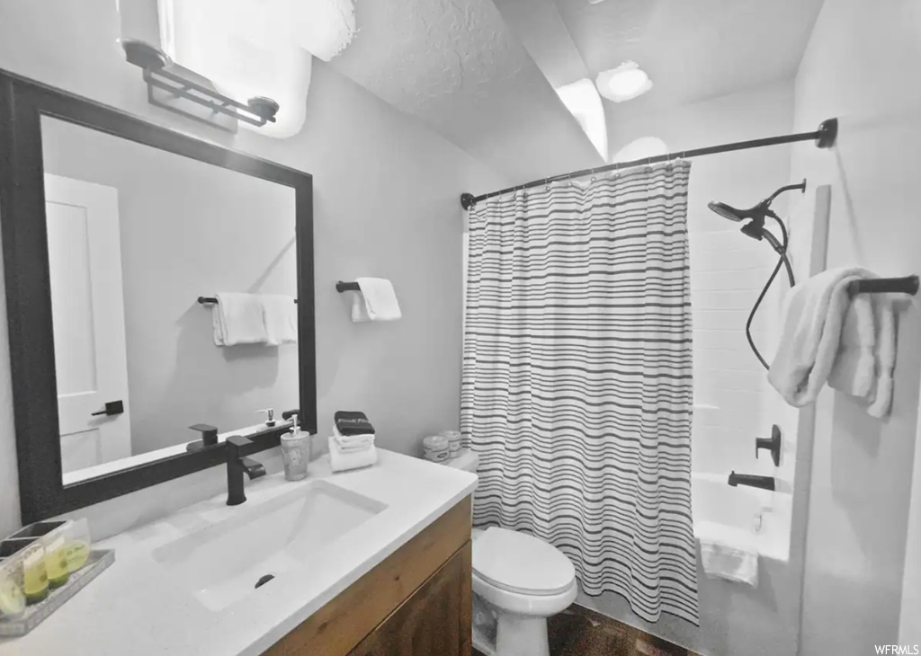 Full bathroom featuring shower / tub combo, vanity, and mirror