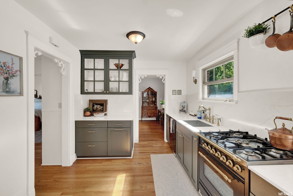 Kitchen featuring light parquet floors, high end black range oven, and light countertops
